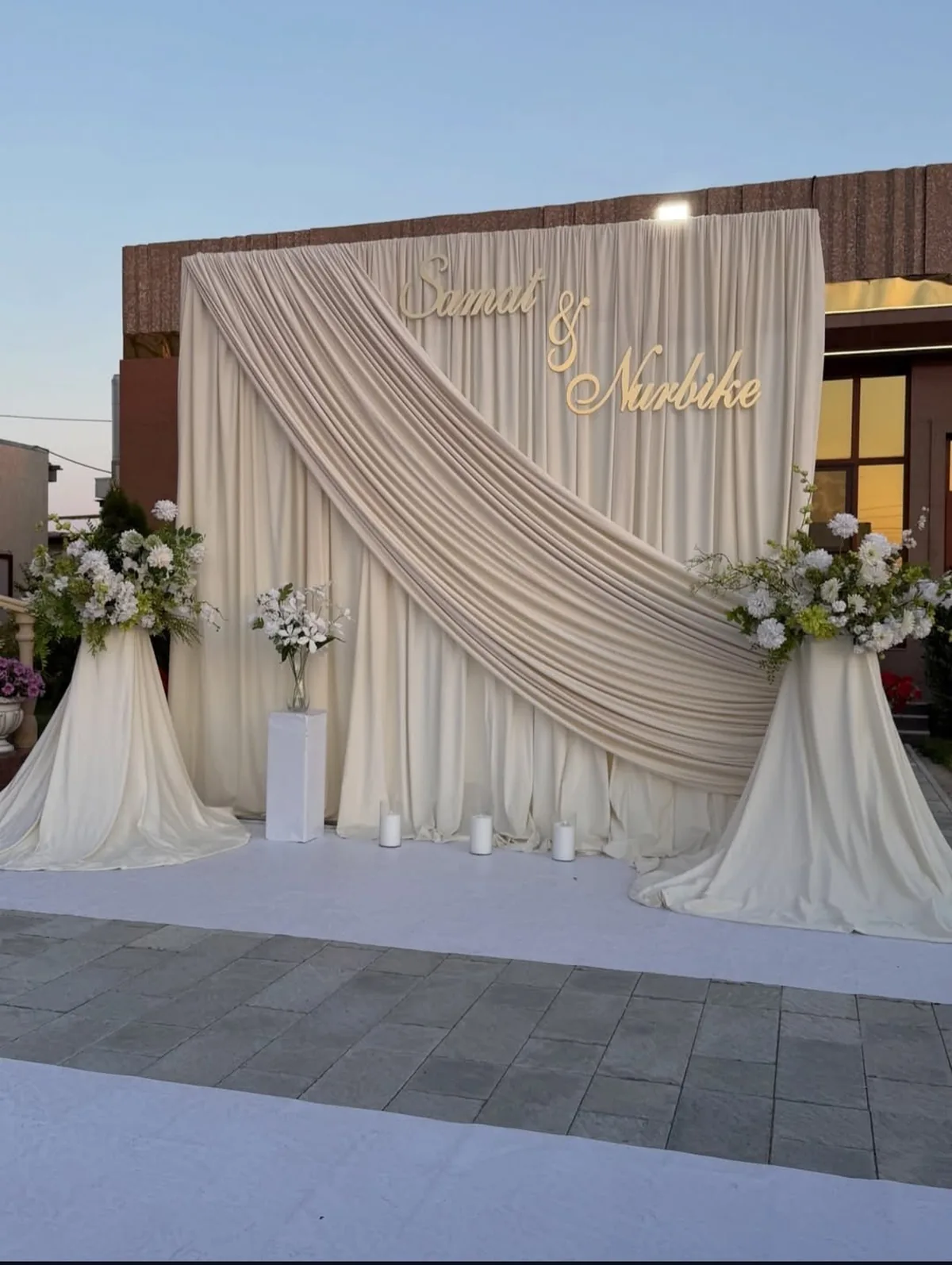 Couple showing rings in front of a designer backdrop